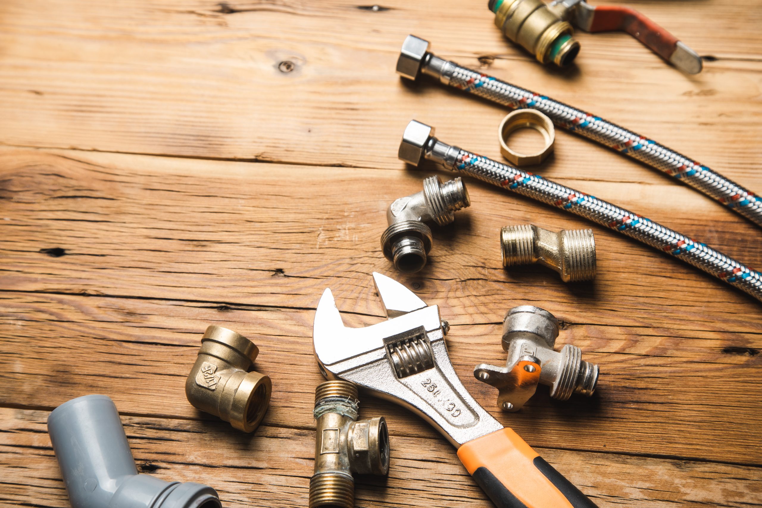 Set of plumbing and tools on the wooden background